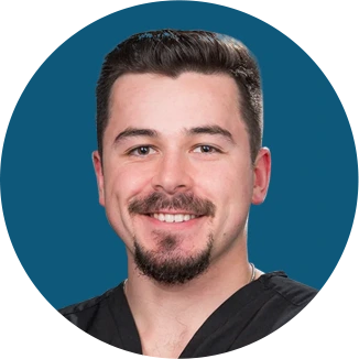 Smiling man with dark hair and beard against teal background