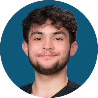 Smiling man with curly dark hair and beard against teal background