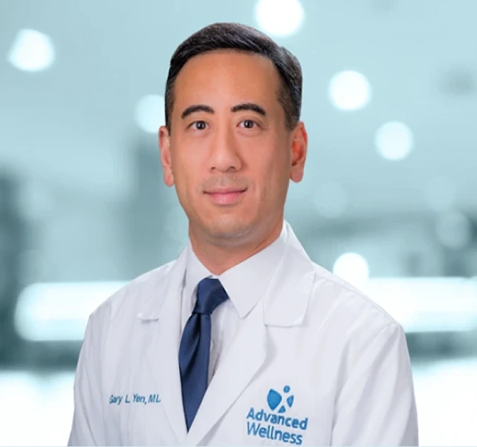 Dr. Sarl L. Yen, MD, in white coat with blue tie against blurred city background
