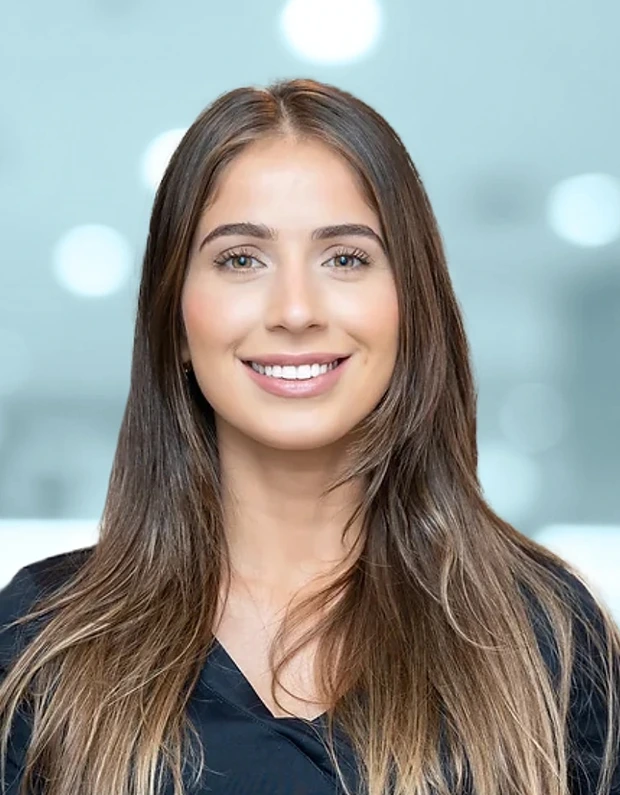 Professional headshot of smiling woman with long brown hair wearing black top