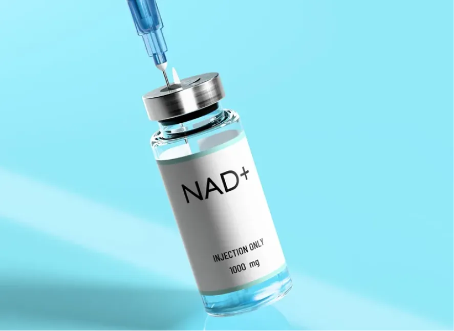 NAD+ injection vial labeled 1000 mg with syringe positioned above it against blue background