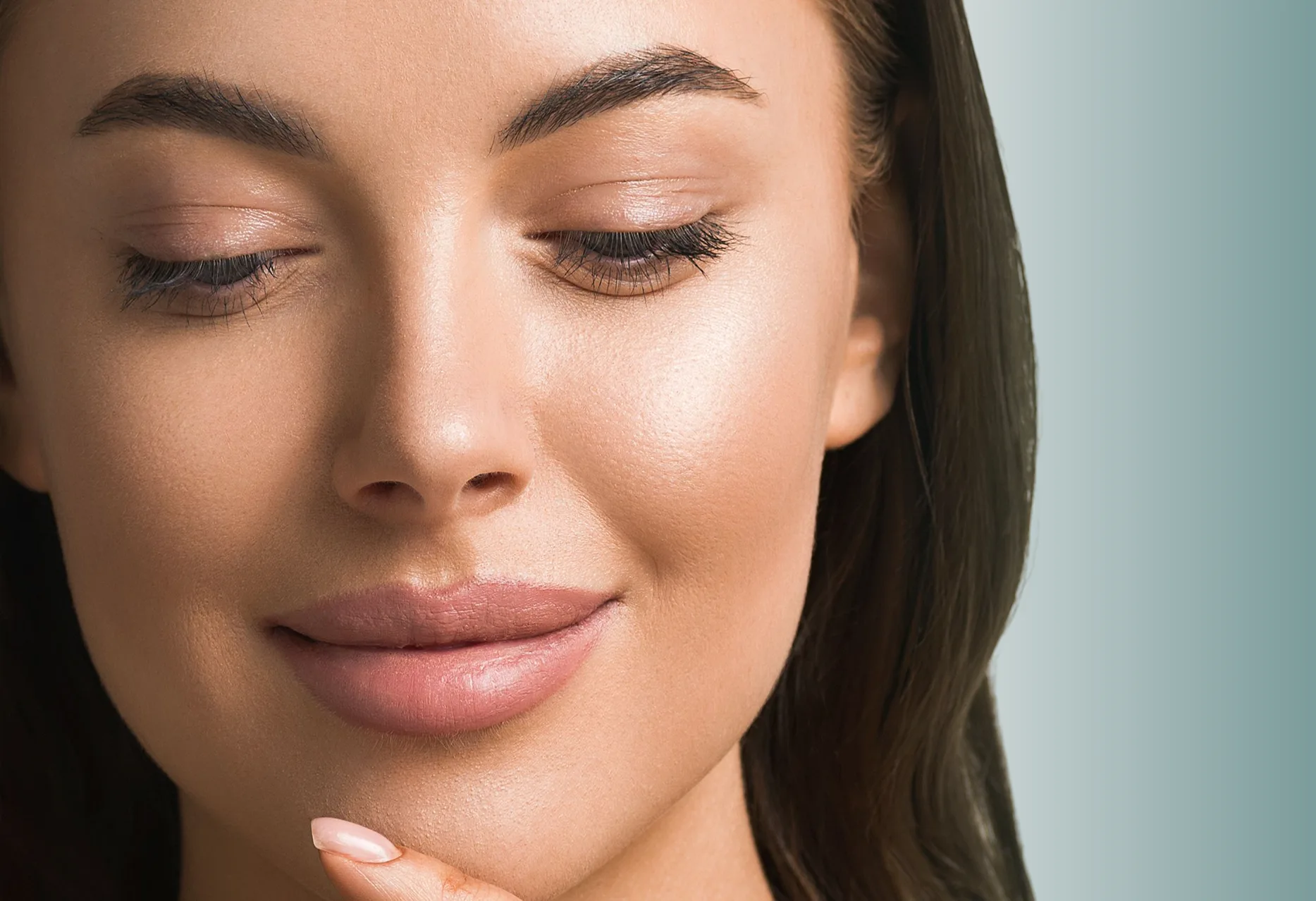Woman's face in profile with eyes closed, showing radiant, clear skin