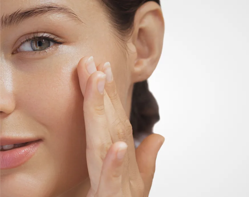 Woman touching her cheek with fingers, showing smooth skin texture