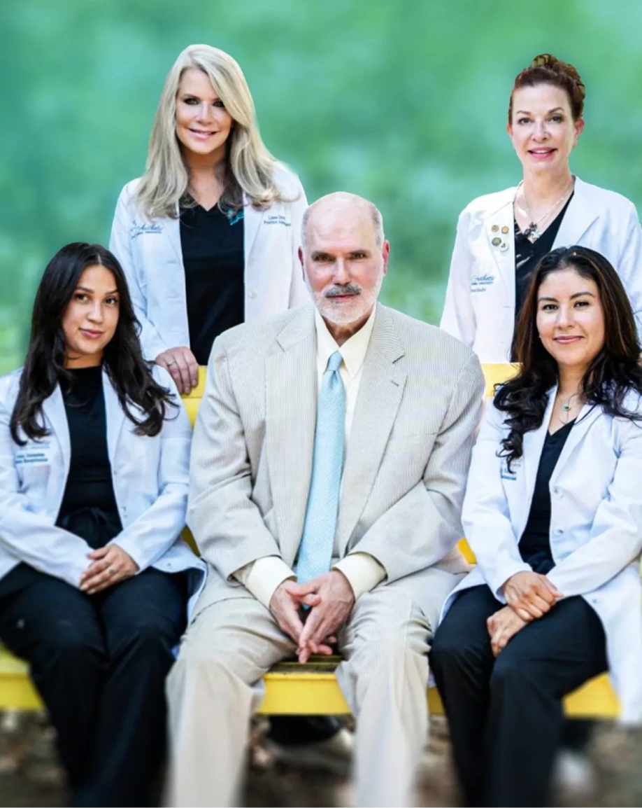 Stephen Eric Metzinger, M.D. and four team members in white coats posed together outdoors