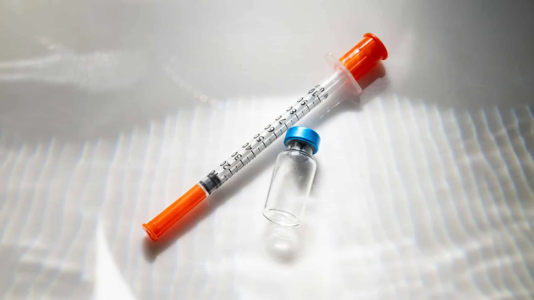 Close-up of an injectable pen syringe and medication vial used for GLP-1 weight-loss treatment such as semaglutide or tirzepatide.