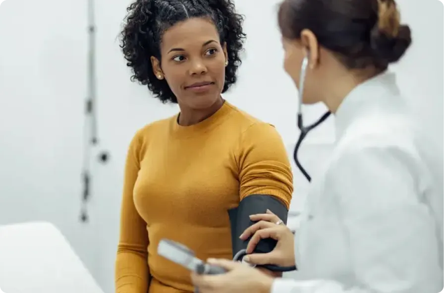 A doctor checks a patient's blood pressure during a primary care exam.