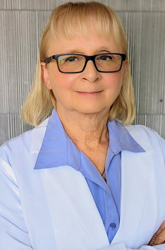 Blonde woman wearing glasses and blue and white medical coat