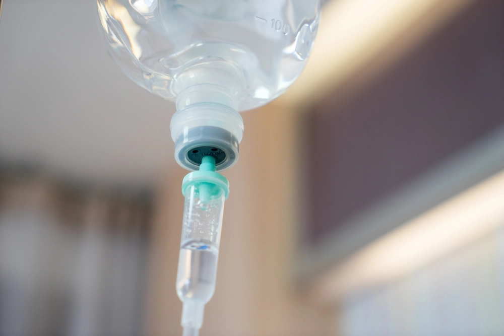 Close-up of IV tubing and drip chamber in a clinic