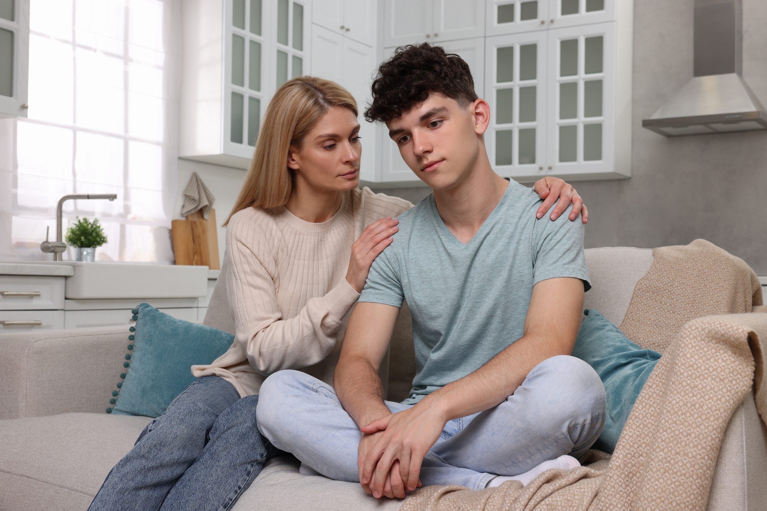 Mother consoling her teenage son at home
