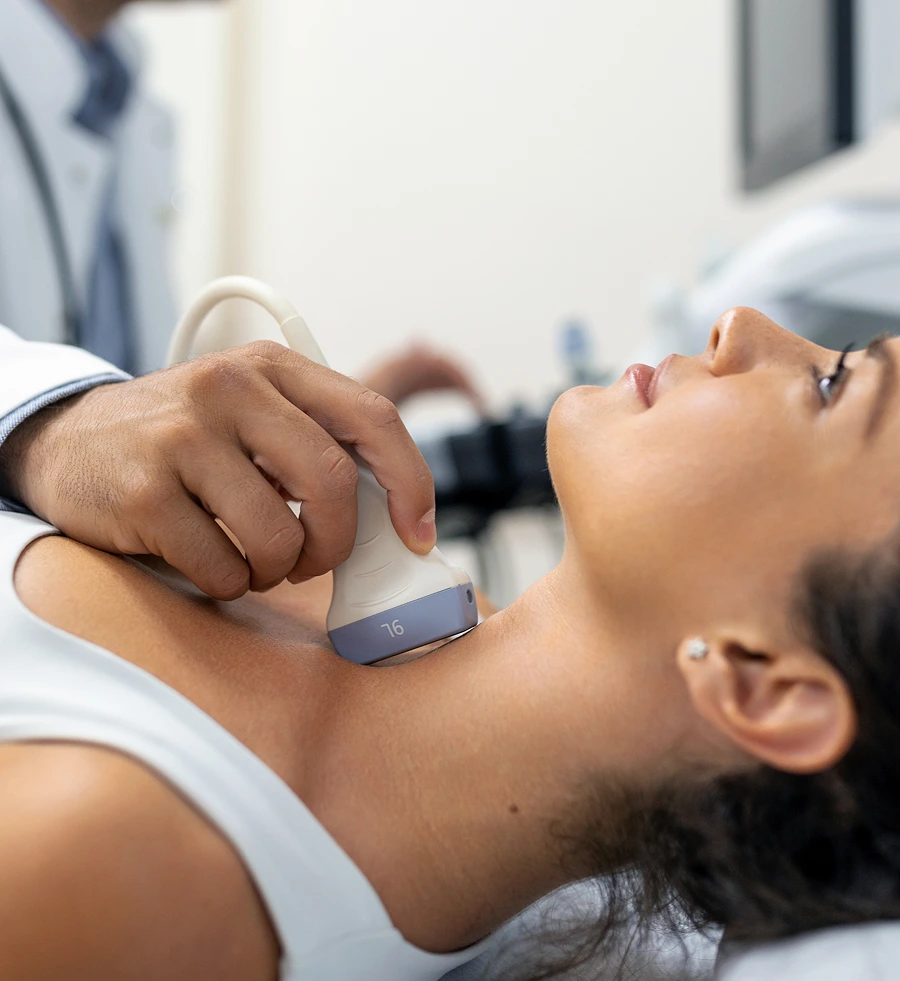 Endocrinologist performing ultrasound examination of patient's thyroid and neck area