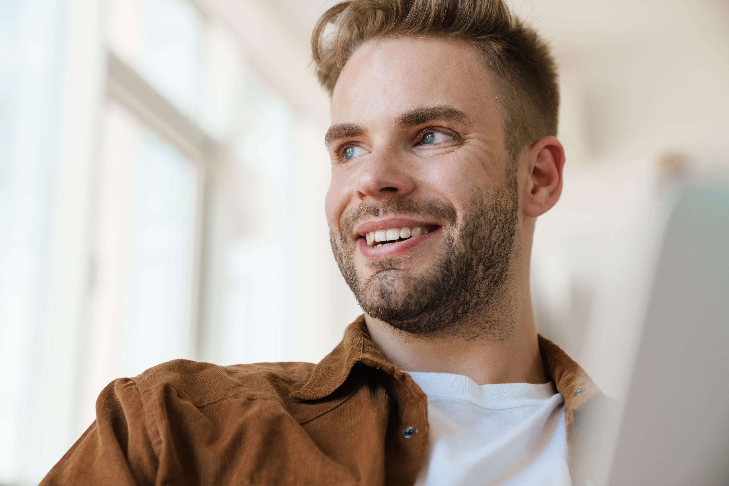 Smiling man in brown shirt indoors