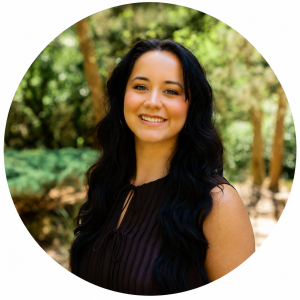Woman with long dark hair smiling in circular portrait with forest background
