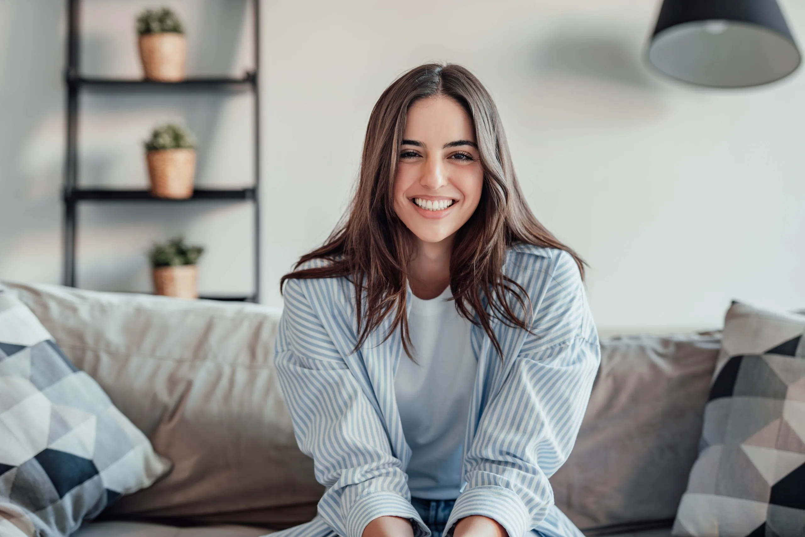 Woman smiling while sitting on a couch in a modern living room