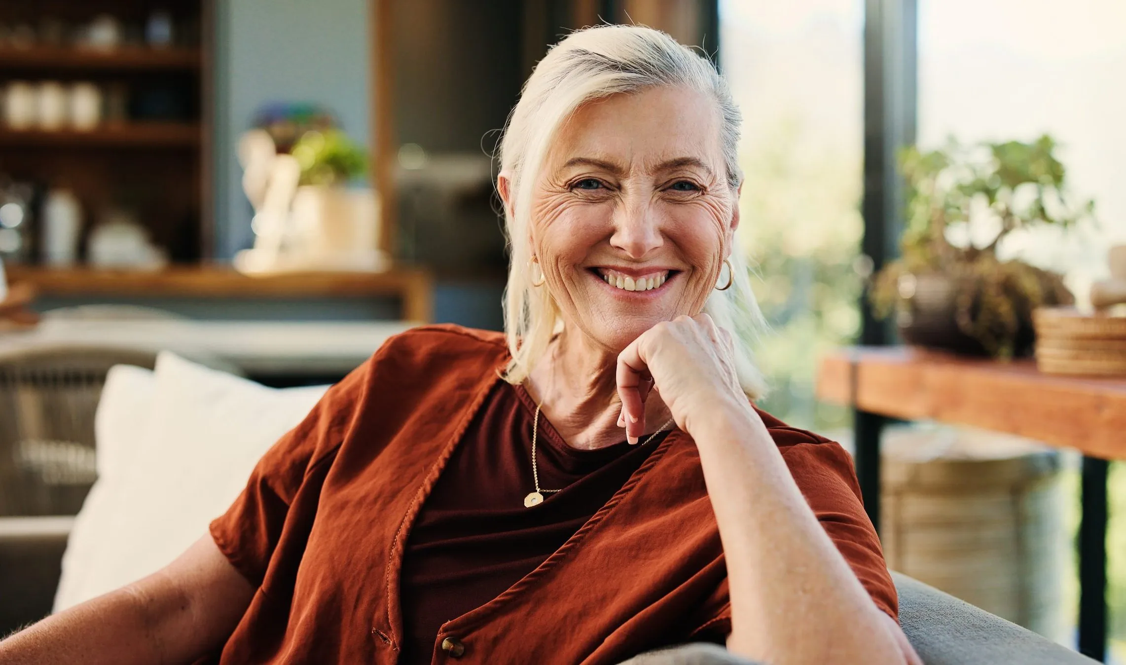 Senior woman smiling at home in a comfortable living room setting
