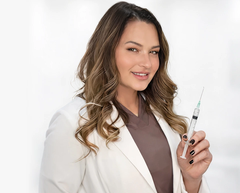 Aesthetician in white coat holding syringe for injection treatment