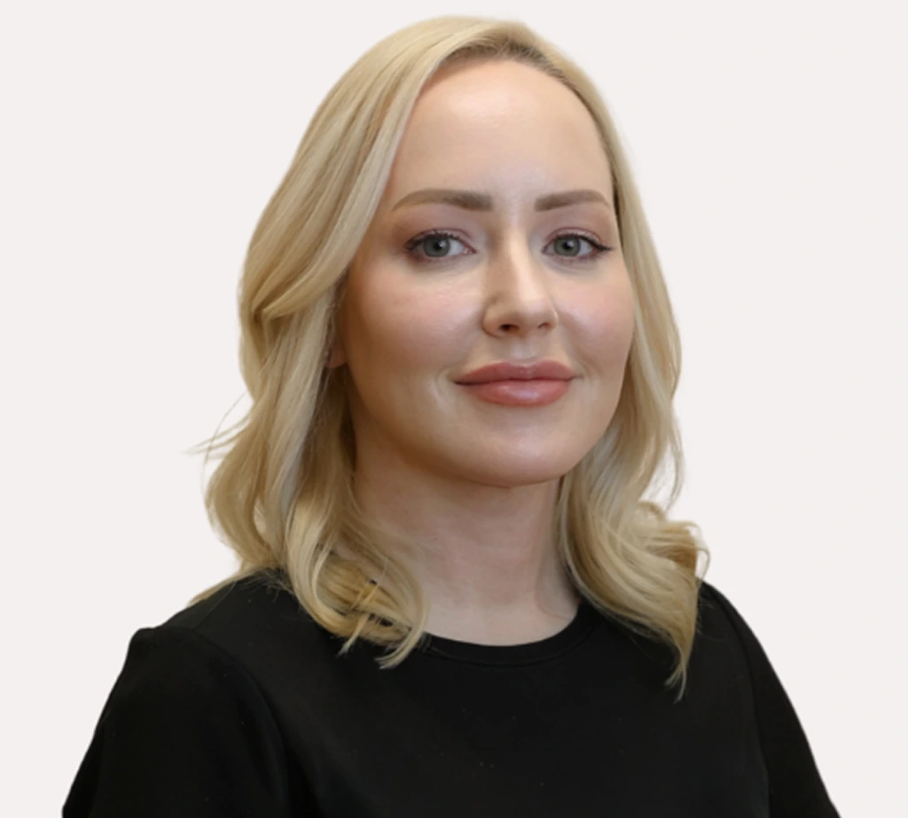 Woman with blonde wavy hair and neutral expression facing forward