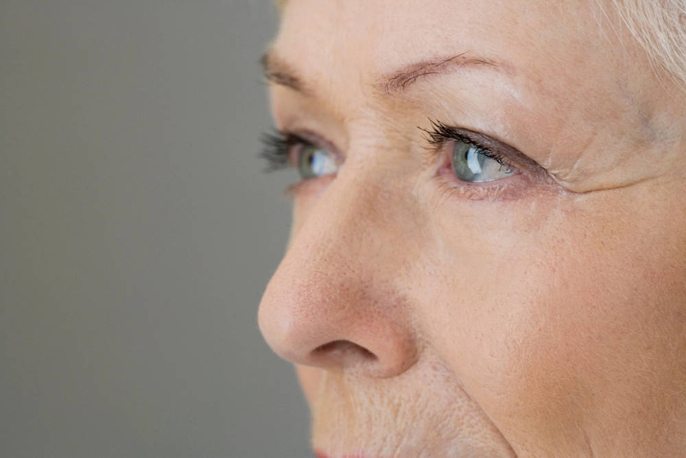 Close-up of mature woman's face showing wrinkles around eyes and mouth