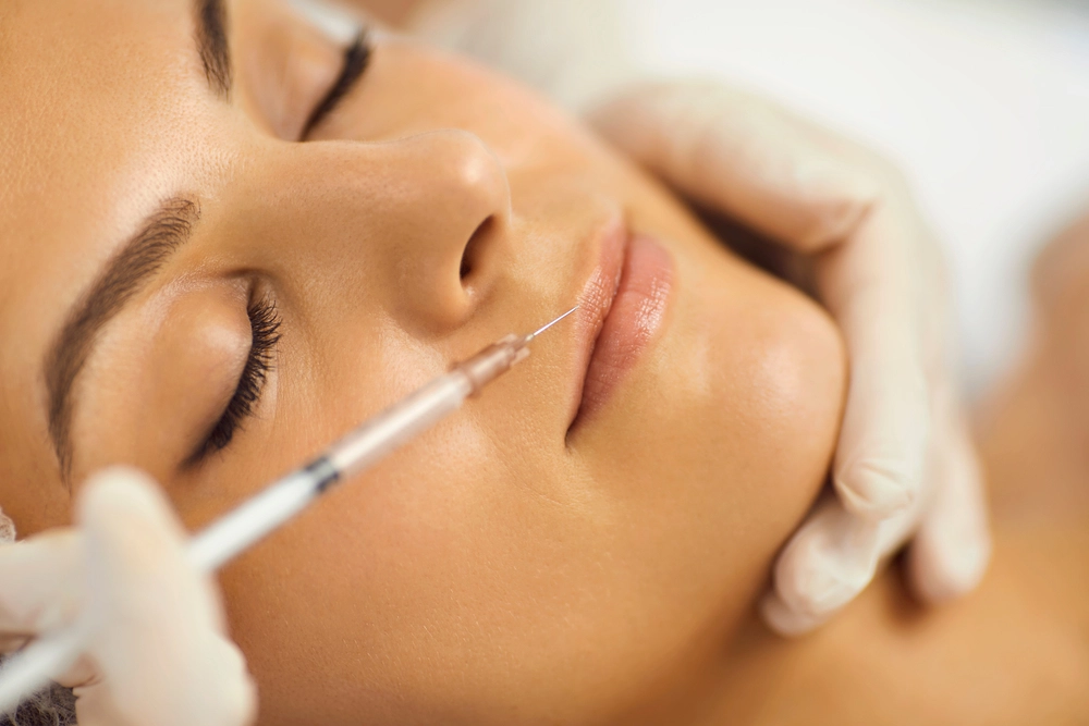 Practitioner administering injectable treatment to patient's cheek