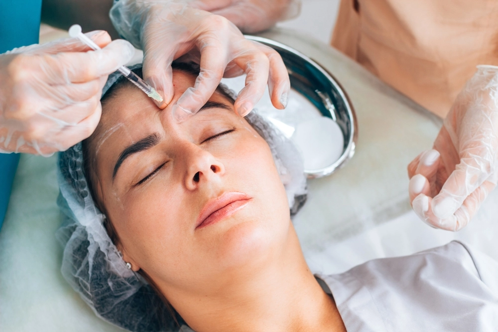 Esthetician applying chemical peel treatment to patient's face