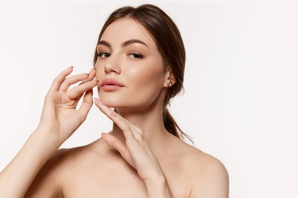 Woman touching her cheek and examining her skin complexion