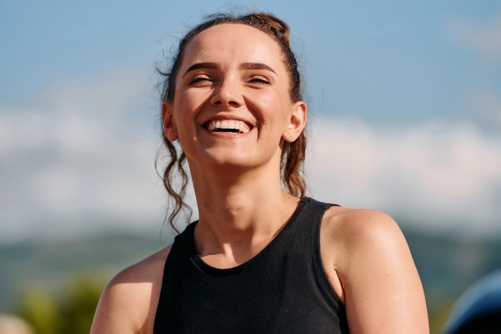 Woman smiling outdoors in athletic wear