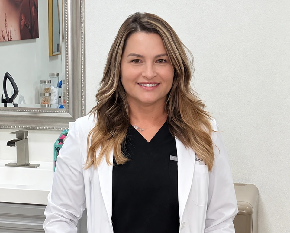 Stephanie Duffy smiling in a white coat at the Peoria medspa location
