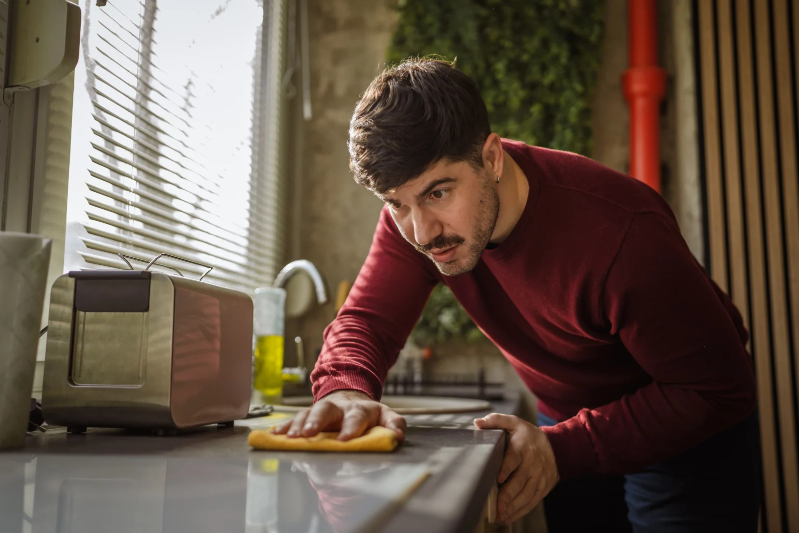 Man repeatedly cleaning a kitchen counter, a common OCD behavior
