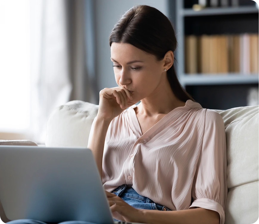 Woman sitting with a laptop, deep in thought