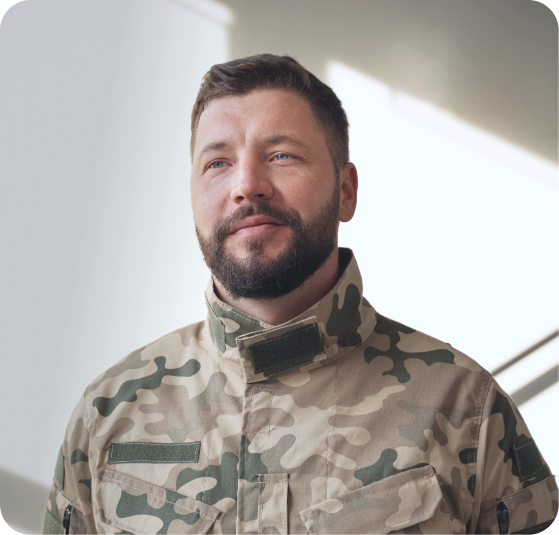 Man in tan camouflage military uniform against white background
