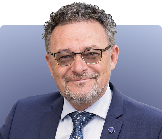Male doctor wearing glasses and dark suit with patterned tie against blue background