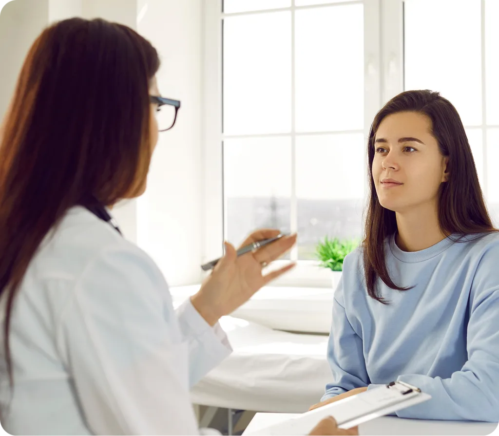 Healthcare provider in white coat consulting with patient at bright office window