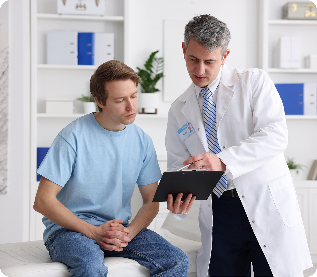 Doctor in white coat showing tablet to young patient in clinical office