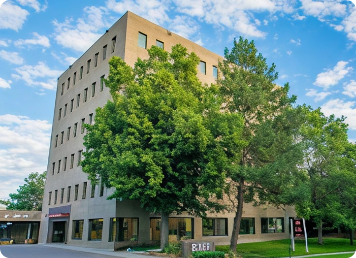 Brilliant Family Dentistry Main Office exterior in Denver, CO, a multi-story tan building with large windows and mature trees