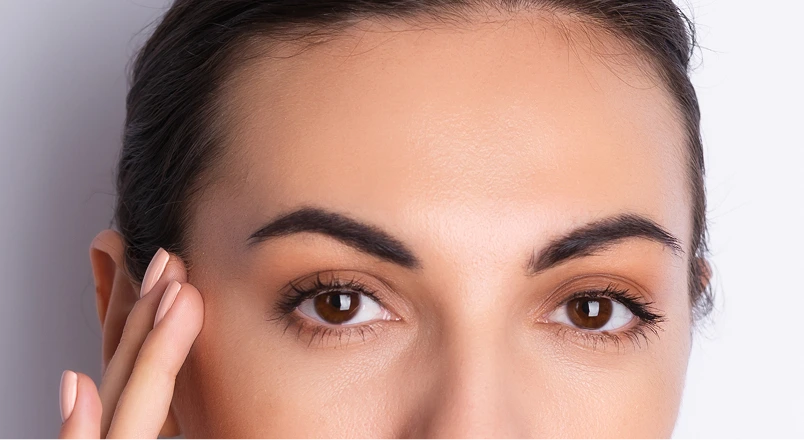 Woman touching her forehead and temple, demonstrating facial area for Botox treatment