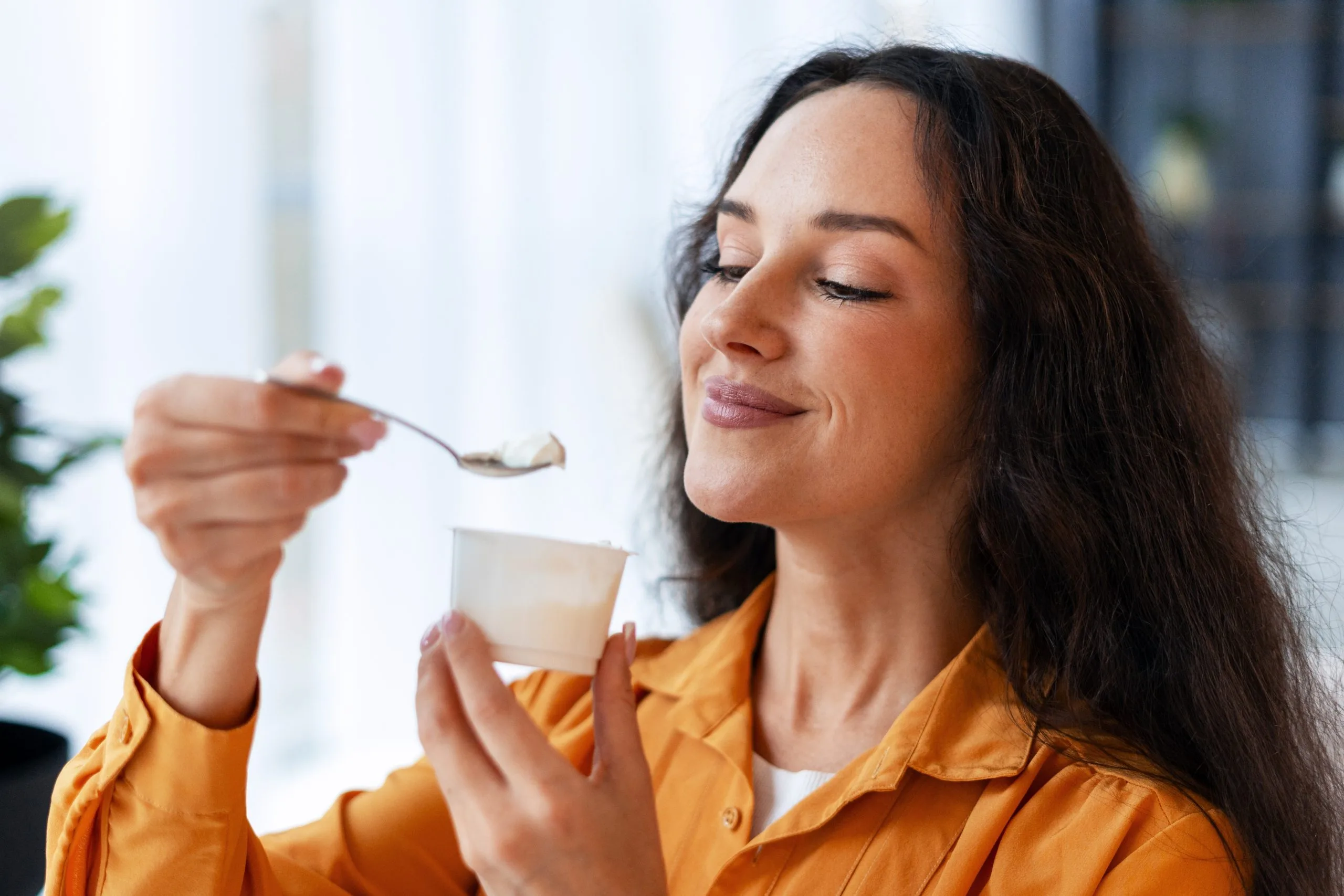 Woman eating soup with a spoon from a bowl