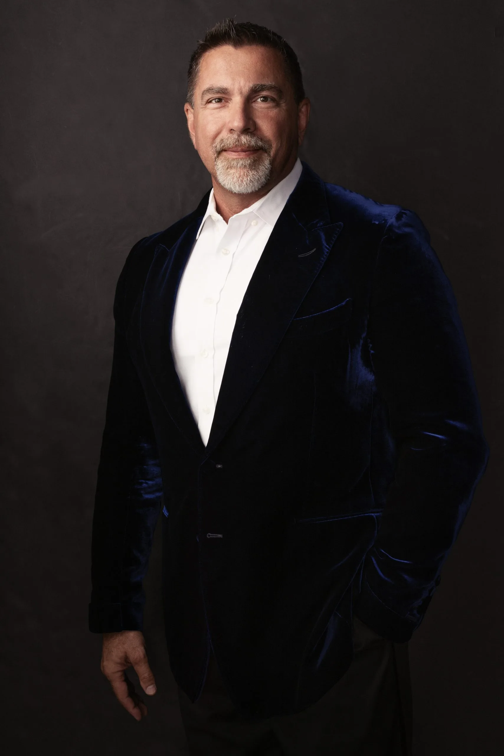 Man in navy velvet blazer and white dress shirt, professional headshot