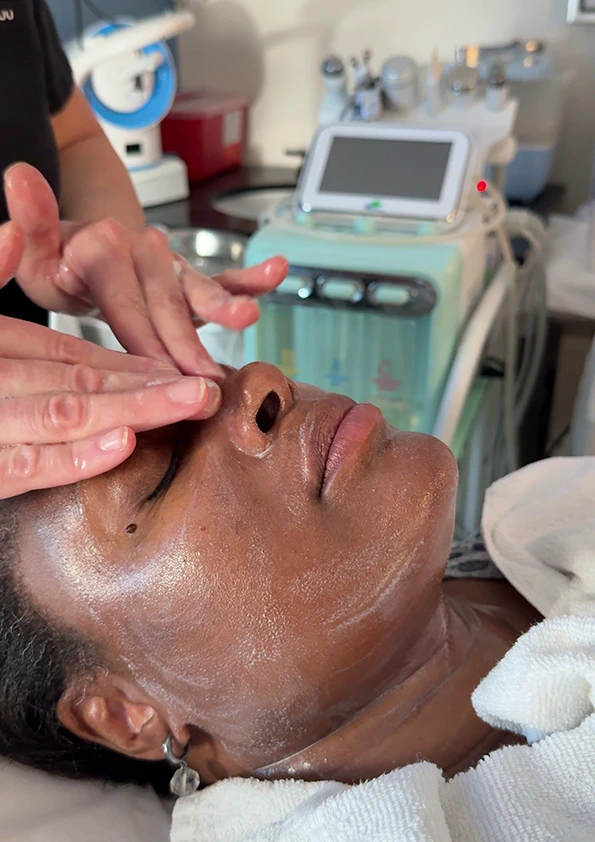 Provider performing deep cleansing facial treatment on patient with handheld device