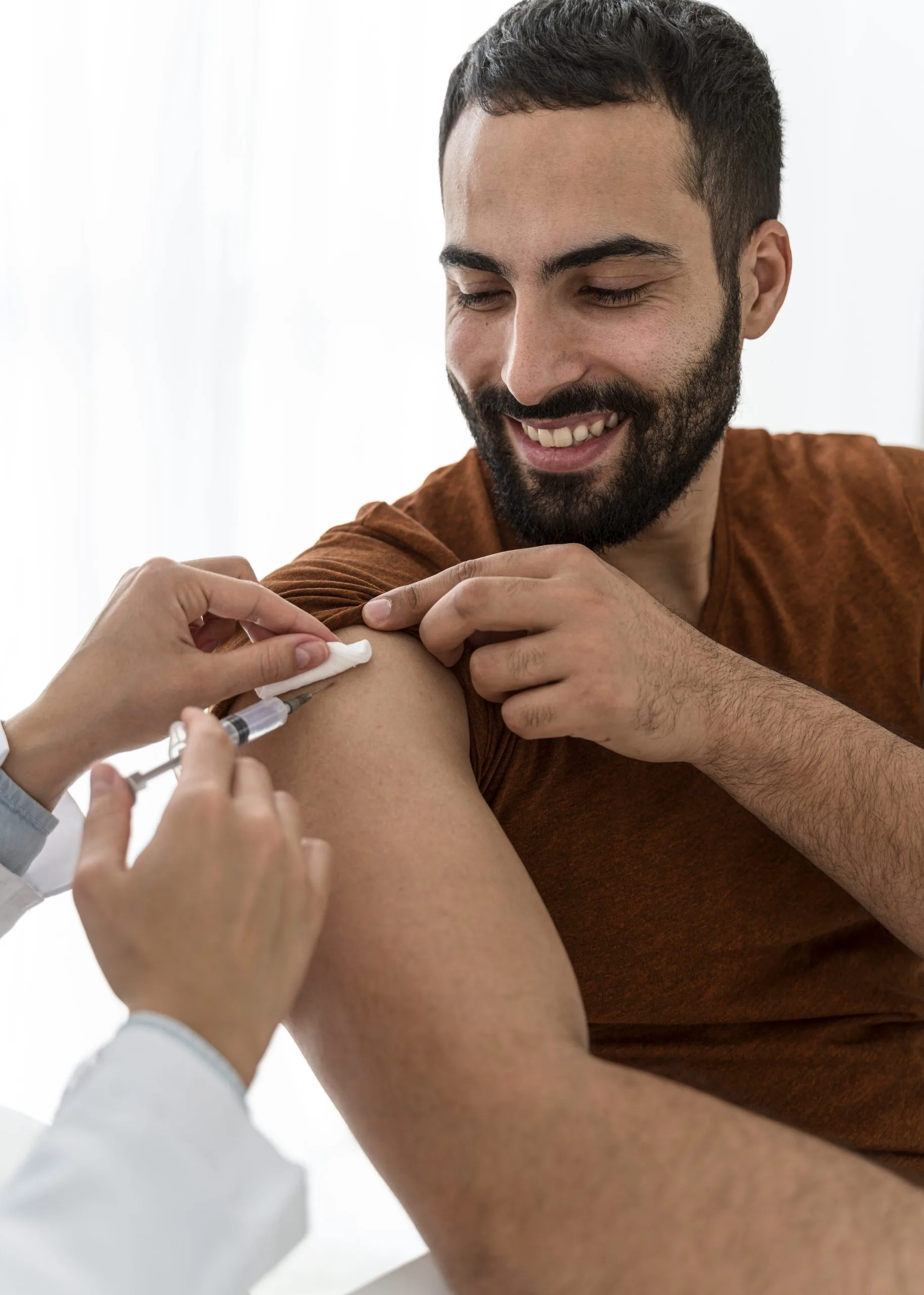 Provider injecting vaccine into bearded man's shoulder