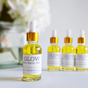 Four bottles of GLOW oil for thirsty skin with lemongrass and rose hip seed oil, dropper caps with gold ferrules
