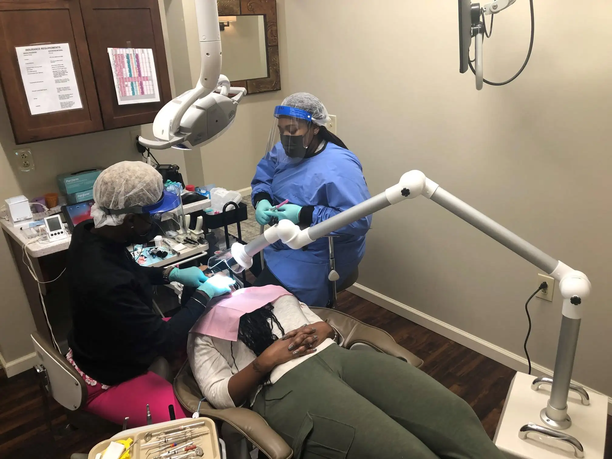 Dental team in protective gear treating a patient during a professional cleaning at Advanced Dentistry of Collegeville