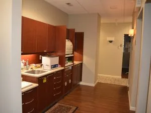 Advanced Dentistry of Collegeville back office with dark wood cabinetry, sink, and sterilization equipment