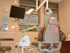 STA System anesthetic delivery device mounted above dental chair in treatment room at Advanced Dentistry of Collegeville