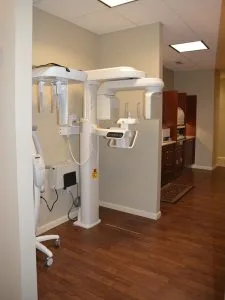 Panoramic dental X-ray machine in Advanced Dentistry of Collegeville treatment room with wood flooring and cream walls