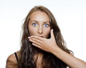 Woman with hand over mouth expressing concern about bad breath