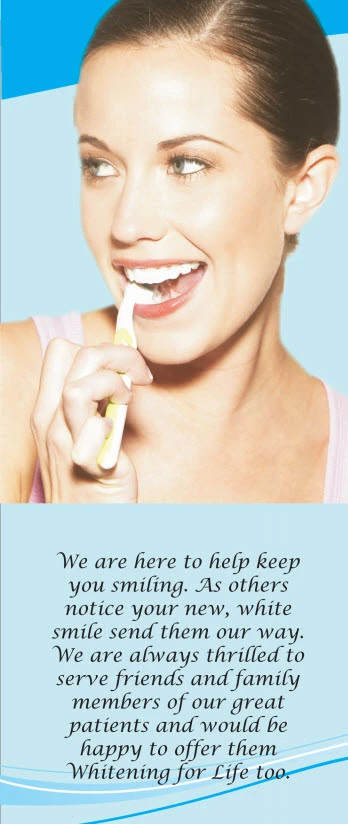 Woman smiling brightly while holding a whitening tray against her teeth
