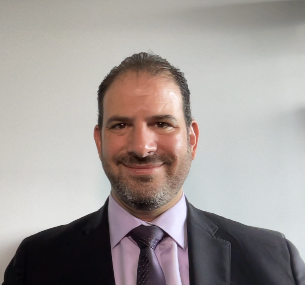 Dr. Adam Shapiro, dentist at Contemporary Care, in professional headshot with purple shirt and tie