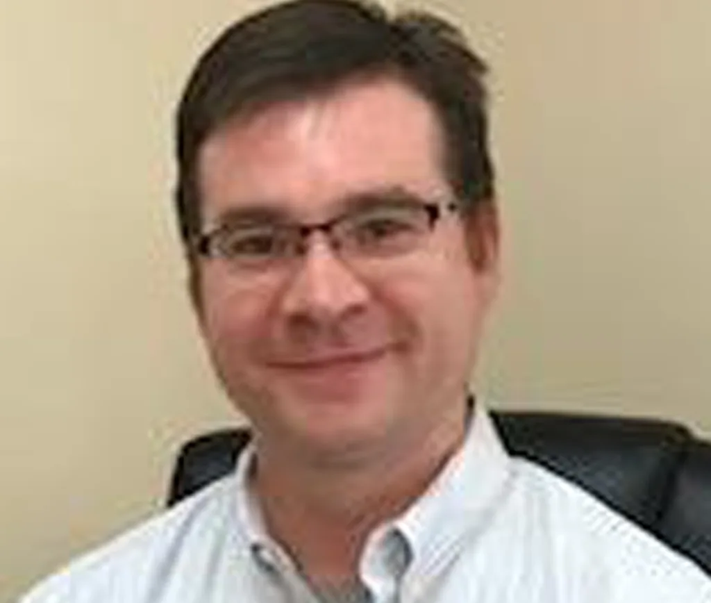 Dr. Ammerman, man with dark hair and glasses wearing a light blue shirt