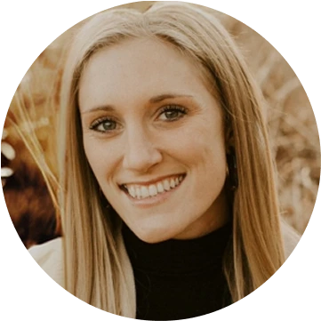 Professional headshot of smiling woman with blonde hair wearing black top