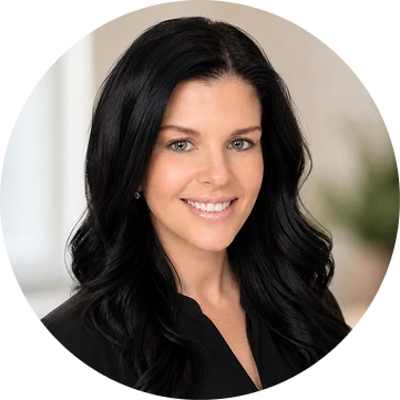 Professional headshot of smiling woman with long black hair wearing dark blazer