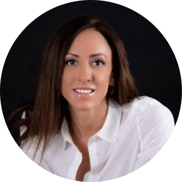 Smiling woman with shoulder-length dark brown hair wearing a white blouse